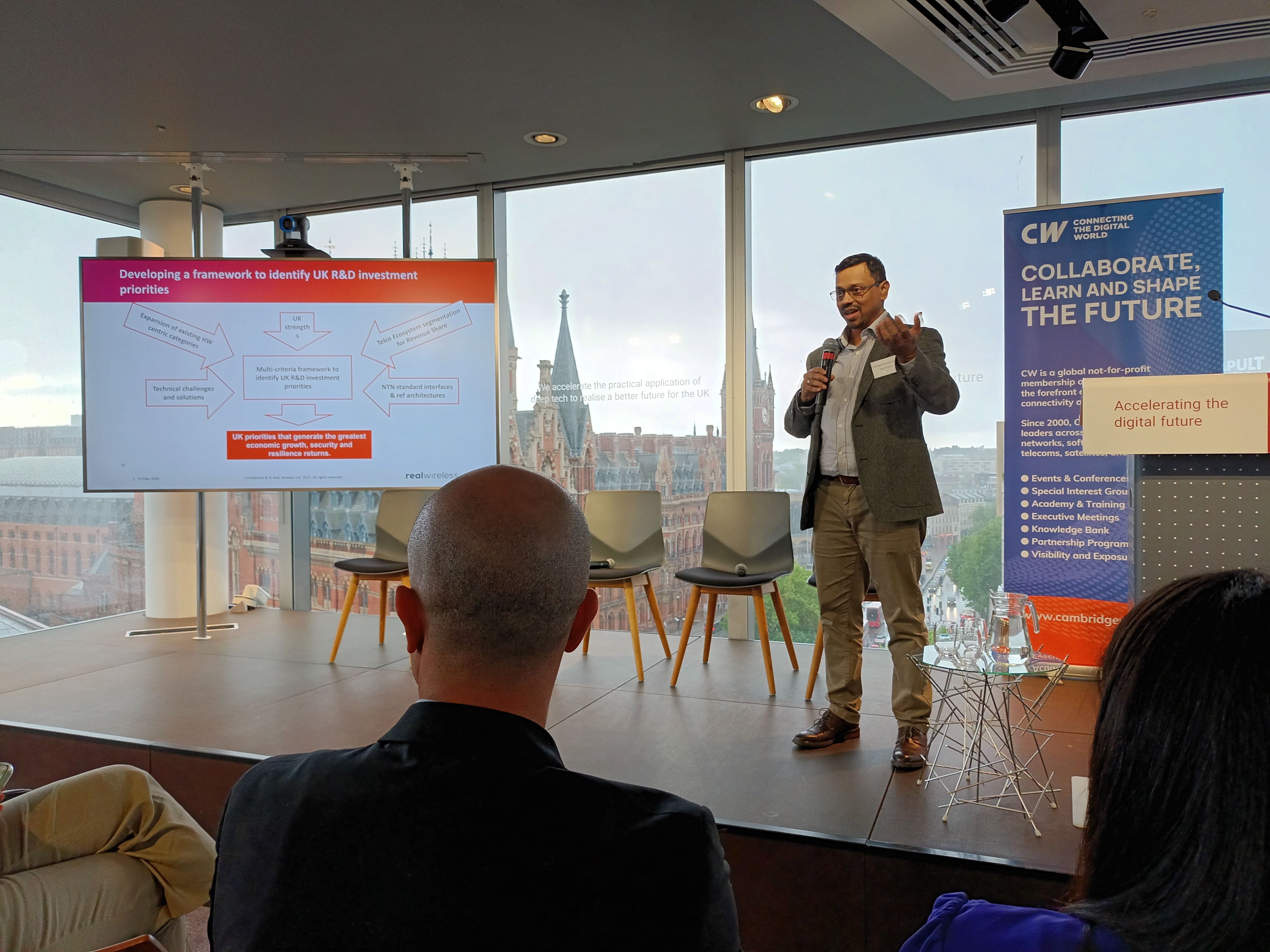 A speaker presents a slide on developing a framework to identify UK R&D investment priorities at a Cambridge Wireless event