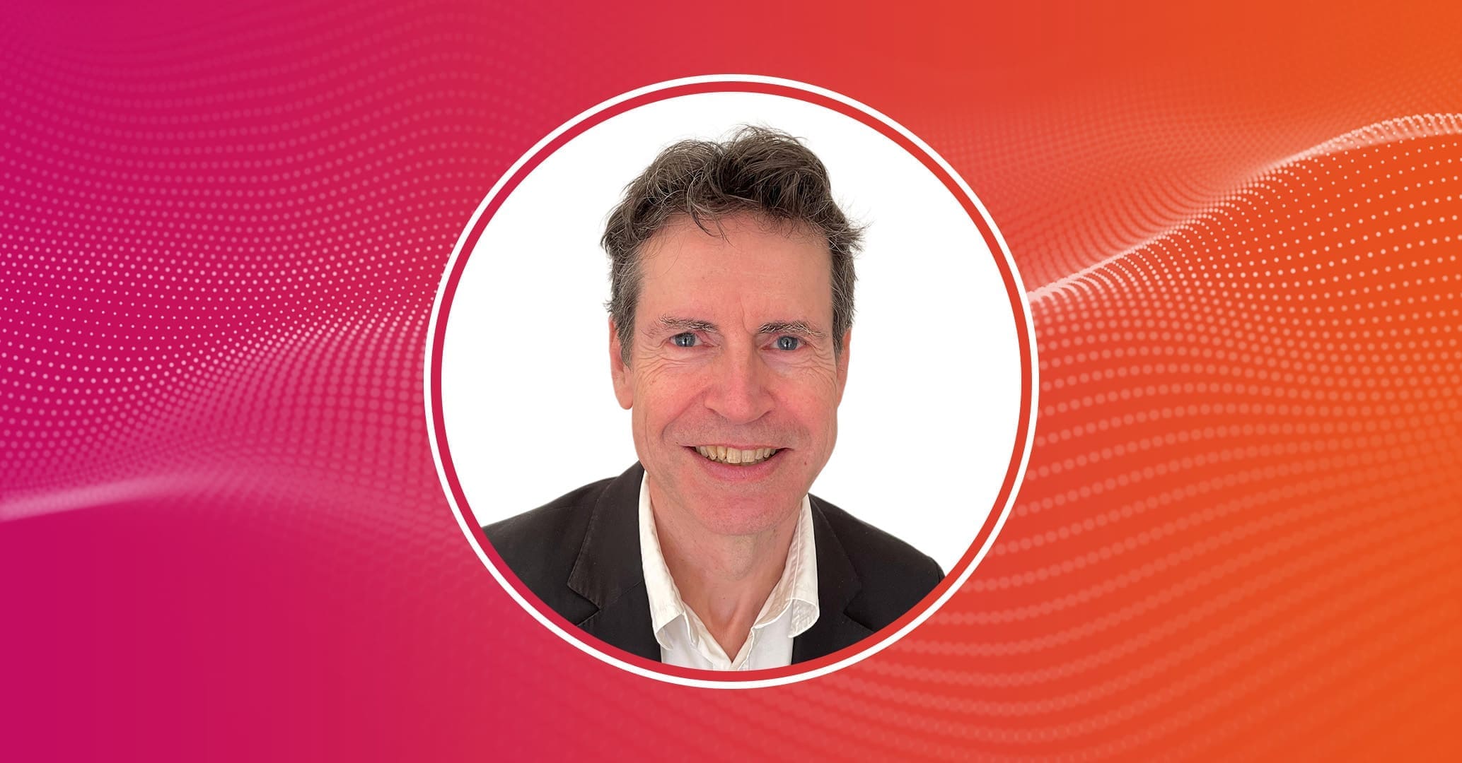 Headshot of a smiling man in a dark blazer and white shirt, framed in a circular border on a pink-to-orange gradient background